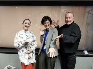 ラジオ番組MCの二人と笑顔でポーズをとる冨田室長